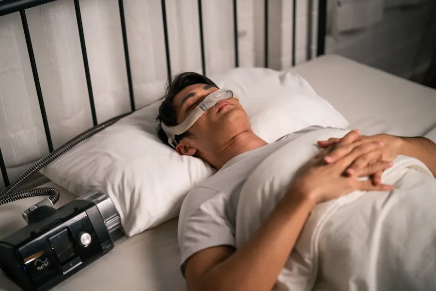 Man Sleeping with CPAP Machine in Bedroom